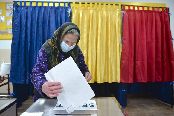 An elderly woman casts her vote in the village of Sabareni, Romania, Sunday, Dec. 6, 2020. Voting started in Romania&#039;s legislative election expected to restore some measure of stability after fiv ...