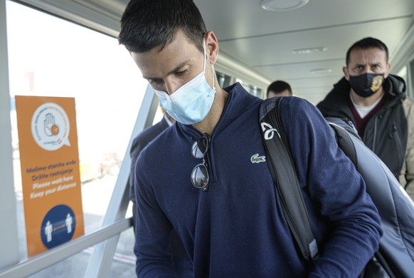 Novak Djokovic looks as his documents after landing in Belgrade, Serbia, Monday, Jan. 17, 2022. Djokovic arrived in the Serbian capital following his deportation from Australia on Sunday after losing  ...