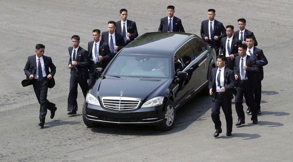 CORRECTS SPELLING OF MOON JAE-IN - North Korean security persons run by a car carrying North Korean leader Kim Jong Un return to the North side for a lunch break after a morning session of a summit me ...
