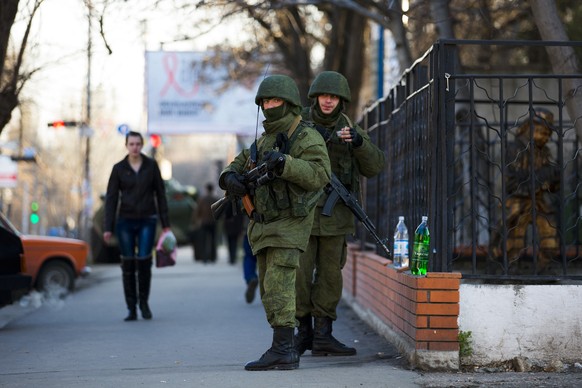 Armed men, believed to be Russian soldiers, stand guard outside a Ukrainian military base in Simferopol March 19, 2014. Defying Ukrainian protests and Western sanctions, Russian President Vladimir Put ...