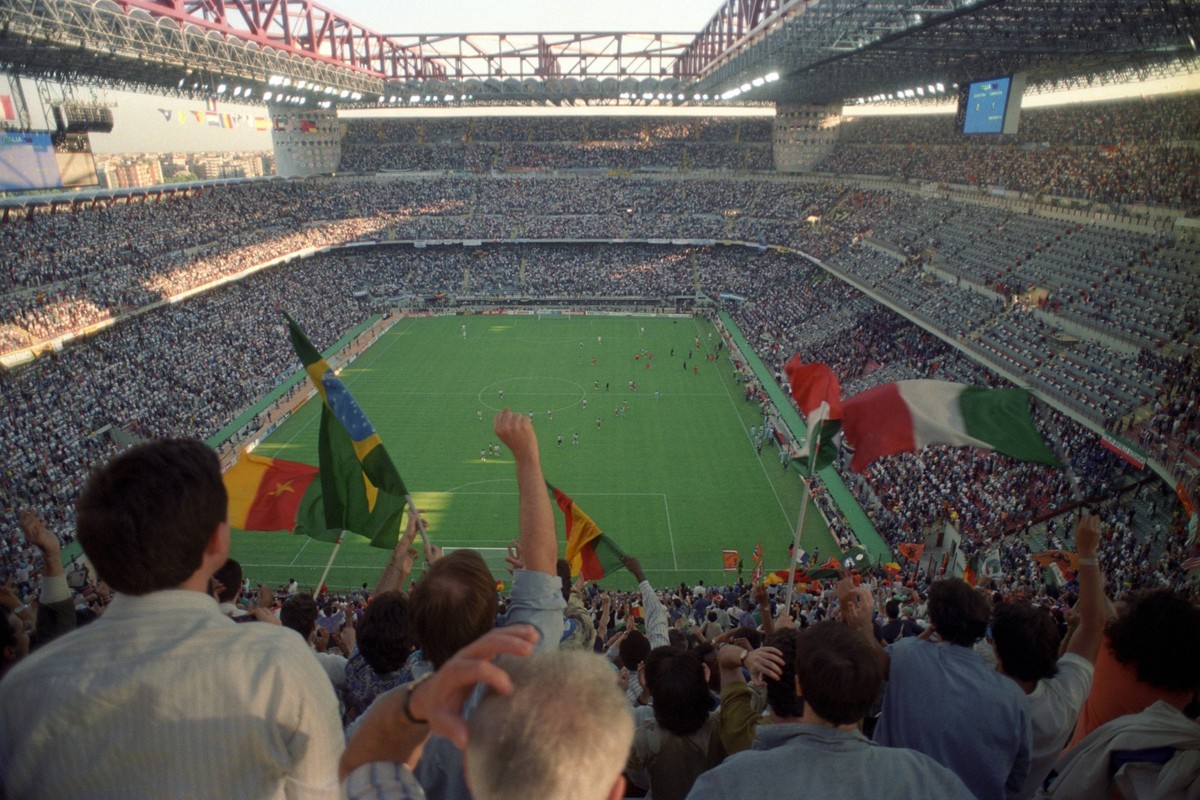 IMAGO / Ferdi Hartung

Fußballfans verfolgen das Eröffnungsspiel der Weltmeisterschaft 1990 zwischen Kamerun und Argentinien im Giuseppe Meazza Stadion in Mailand