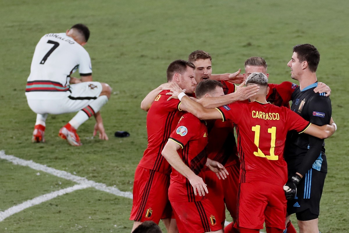 Belgium players celebrate winning 1-0 as Portugal's Cristiano Ronaldo, 7, reacts after the Euro 2020 soccer championship round of 16 match between Belgium and Portugal at La Cartuja stadium in Se ...