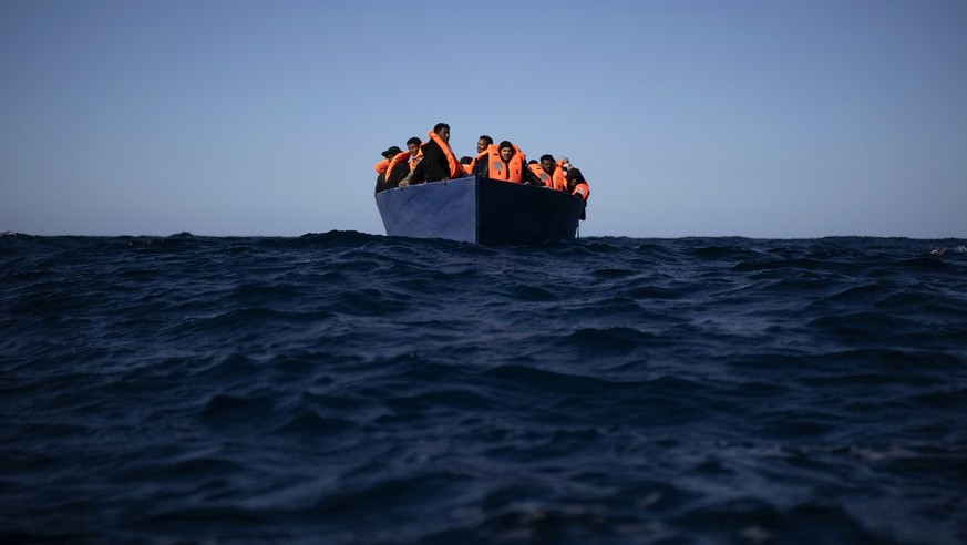 Migrants from Eritrea, Egypt, Syria and Sudan, wait to be assisted by aid workers of the Spanish NGO Open Arms, after fleeing Libya on board a precarious wooden boat in the Mediterranean sea, about 11 ...