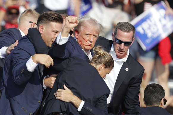 epa11476882 Former US President Donald Trump is rushed off stage by secret service after an incident during a campaign rally at the Butler Farm Show Inc. in Butler, Pennsylvania, USA, 13 July 2024. Fo ...