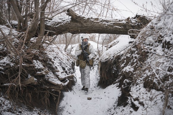A Ukrainian serviceman patrols along a frontline position outside Avdiivka, Donetsk region, eastern Ukraine, Saturday, Feb. 5, 2022. The French president and the German chancellor will head to Moscow  ...