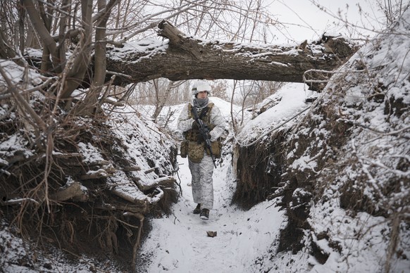 A Ukrainian serviceman patrols along a frontline position outside Avdiivka, Donetsk region, eastern Ukraine, Saturday, Feb. 5, 2022. The French president and the German chancellor will head to Moscow  ...