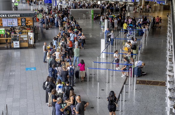 Passengers queue at the check in counters at the airport in Frankfurt, Germany, Monday, July 25, 2022. The Lufthansa ground staff will go for a warning strike next Wednesday. (AP Photo/Michael Probst)