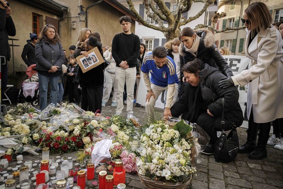 Parents of victims bring flowers as approximately a thousand people gathered to pay tribute to the victims of the tragedy in Crans-Montana and to call for "justice and truth", Saturday, Janu ...