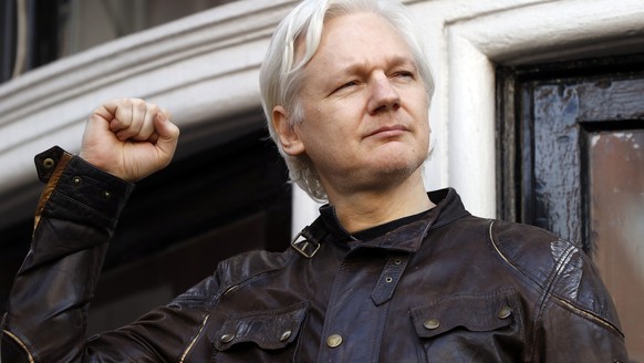 FILE - Julian Assange greets supporters outside the Ecuadorian embassy in London, May 19, 2017. (AP Photo/Frank Augstein, File)