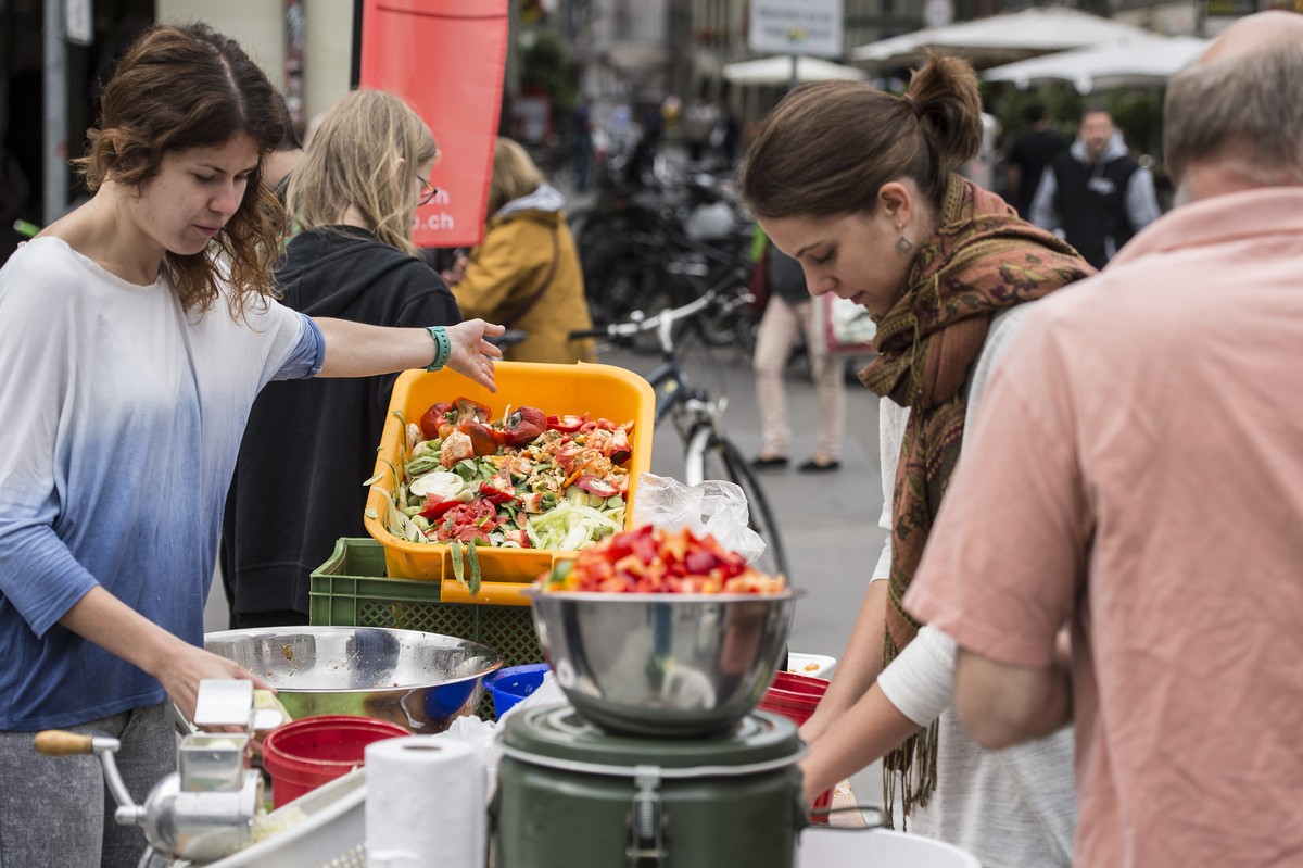 Personen ruesten Gemuese, am Anlass "Bern tischt auf - ein Fest aus ueberschuessigen Lebensmitteln", am Samstag, 23. August 2014, in Bern. Neben den Gratis-Menues aus ueberschuessigen Lebens ...