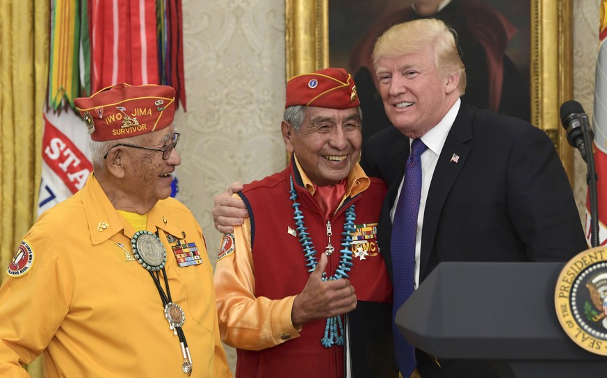 President Donald Trump, right, meets with Navajo Code Talkers Peter MacDonald, center, and Thomas Begay, left, in the Oval Office of the White House in Washington, Monday, Nov. 27, 2017. (AP Photo/Sus ...