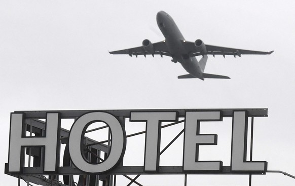 epa08966493 A plane flies over a hotel near Heathrow Airport near London, Britain, 26 January 2021. The British government is expected to approve a plan to require UK citizens to quarantine in a hotel ...