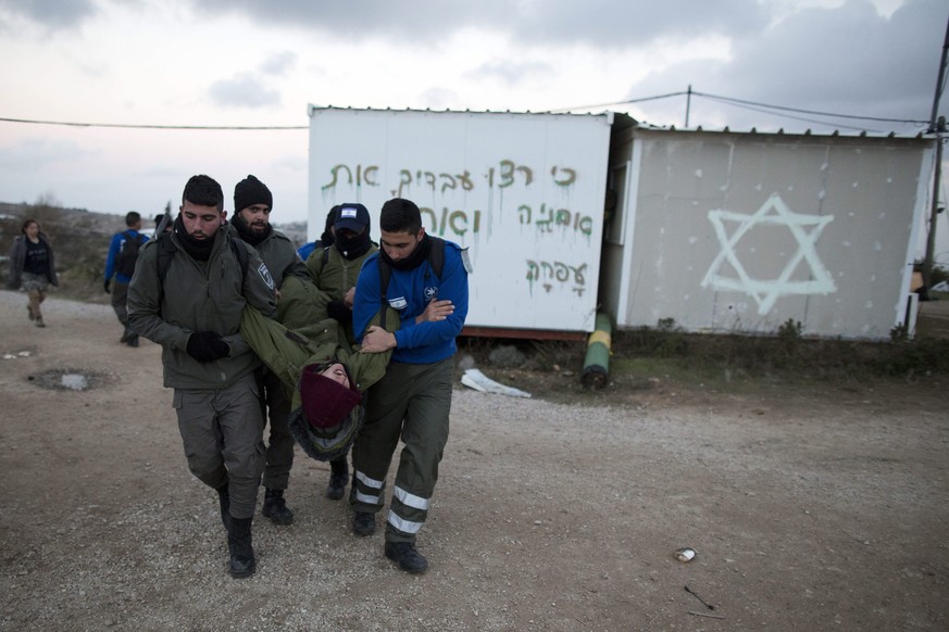 epa05764828 Israeli security forces arrest a settler during the evacuation of the illegal Jewish settlement of Amona, in the West Bank, 01 February 2017. Israeli police have deployed 3,000 policemen a ...