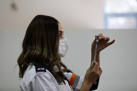 epa09063610 A nurse prepares a shot of COVID-19 vaccine in downtown Jerusalem, 09 March 2021. Israeli government approved the easing of coronavirus restrictions allowing bars, restaurants, event halls ...