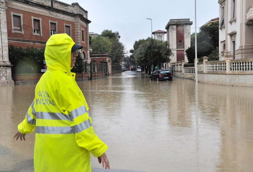 epa06195715 A police officer stands in a flooded crossing in Livorno, Italy, 10 September 2017. According to reports, five people were found dead in a flooded basement after abundant rain. EPA/ALESSIO ...