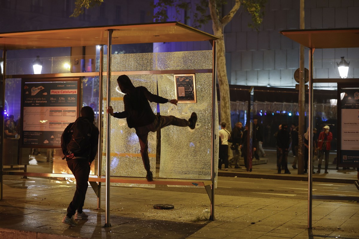 epa13329133 People break a bus stop glass pannel during a student-organized protest at Plaza Catalunya in Barcelona, Spain, 24 October 2026. The protest, called through social media, led to clashes be ...