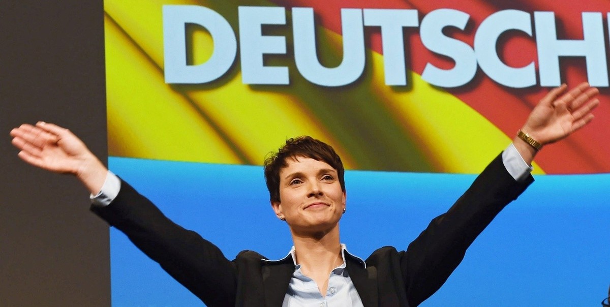 epa05045447 Frauke Petry, co-chairwoman of Alternative for Germany (AfD) party, waves under the writing 'GERMAN' after her speech at the AfD federal convention in Hanover, Germany, 28 Novemb ...