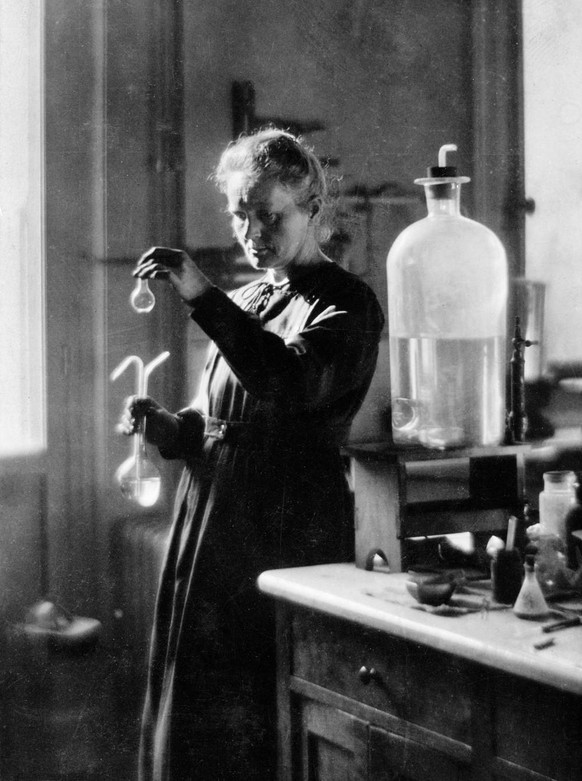 Eines der gestellten Fotos für die Zeitung: Marie Curie mit Radium-Gefässen in den Händen.