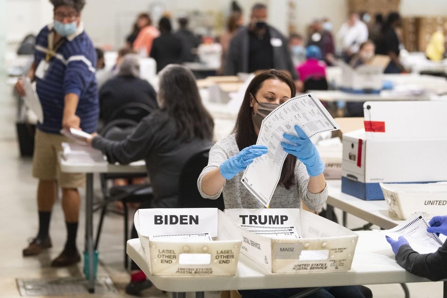 An election worker looks at a ballot during a hand recount of Presidential votes on Sunday, Nov. 15, 2020 in Marietta, Ga. (KEYSTONE/John Amis/Atlanta Journal &amp; Constitution via AP)