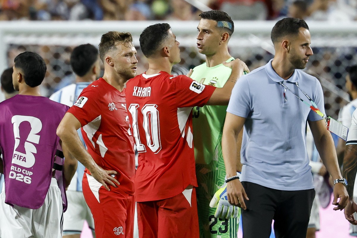epa13106506 Switzerland's Silvan Widmer (L) and Granit Xhaka (C) talks with Argentina's goalkeeper Emiliano Martinez after the FIFA World Cup 2026 quarterfinals match Argentina vs Switzerlan ...