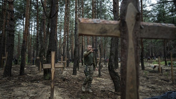 Oleg Kotenko, the Commissioner for Issues of Missing Persons under Special Circumstances uses his smartphone to film the unidentified graves of civilians and Ukrainian soldiers in the recently retaken ...