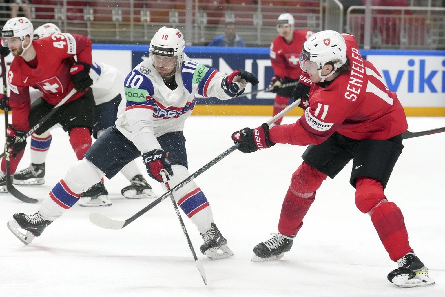 Mattias Norstebo of Norway, left, fights for a puck with Sven Senteler of Switzerland during the group B match between Norway and Switzerland at the IIHF ice hockey world championship in Riga, Latvia, ...