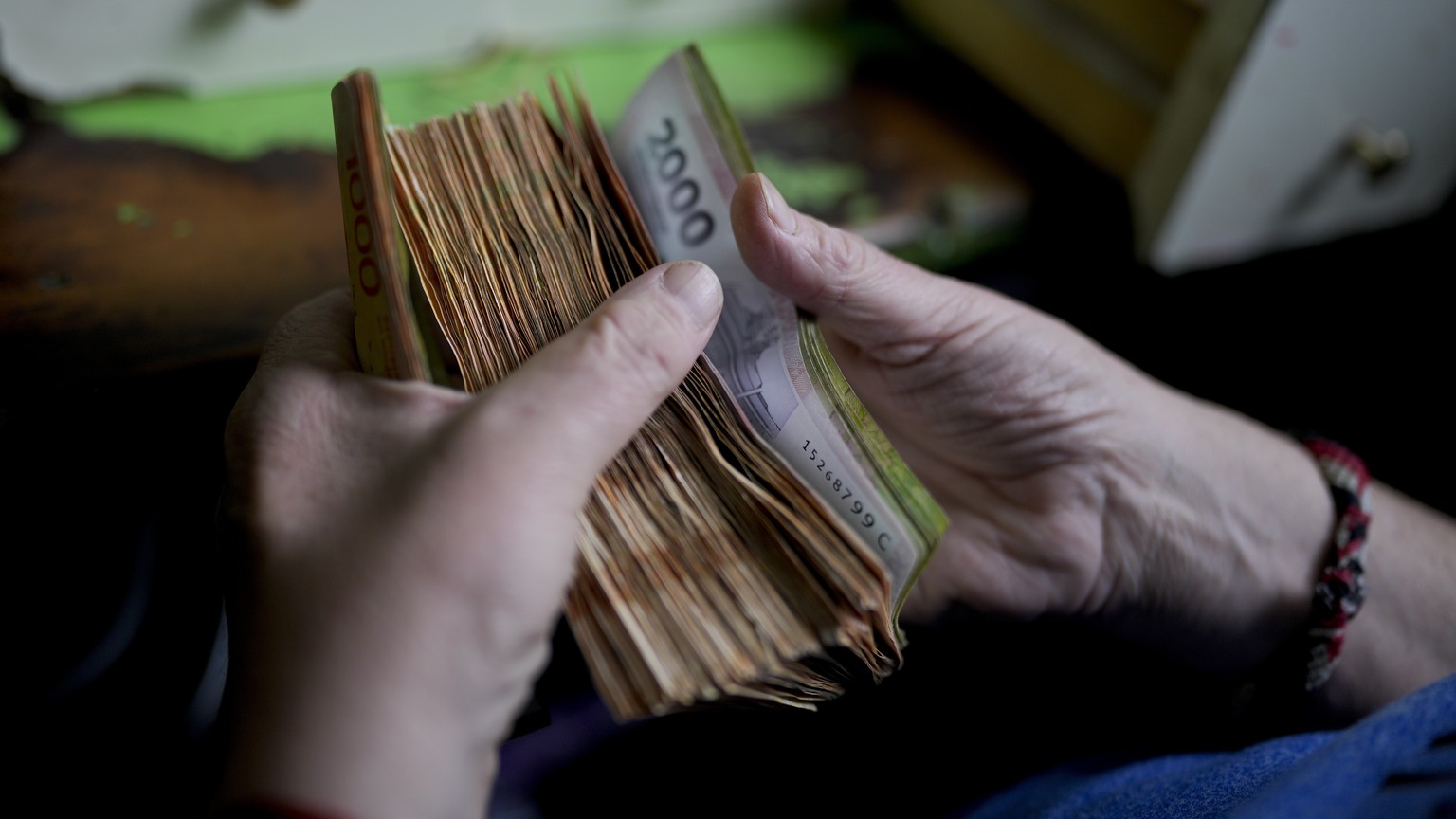 File - A worker counts money at a grocery store in Buenos Aires, Argentina, Nov. 21, 2023. Prices have surged so dramatically that the government has multiplied the size of its biggest banknote in cir ...
