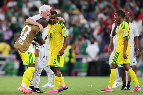 South Africa head coach Hugo Broos, second from left, gets hugged by his players after the won the World Cup Group A soccer match between South Africa and South Korea in Guadalupe, near Monterrey, Mex ...