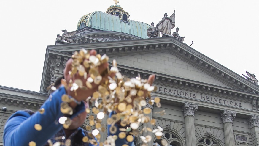 ARCHIV - ZUM SPARBESCHLUSS DES NATIONALRATS BEI DEN BUNDESFINANZEN 2017 STELLEN WIR IHNEN DIESES ARCHIVBILD ZUR VERFUEGUNG - Ein Chinesischer Tourist aus Shanghai laesst einige Muenzen der insgesamt 8 ...