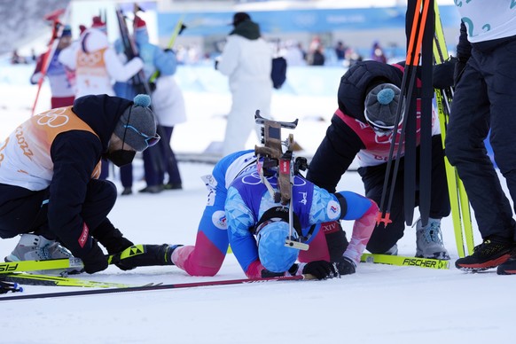Eduard Latypov of the Russian Olympic Committee collapses after the finish line in third place during the men's 4x7.5-kilometer relay at the 2022 Winter Olympics, Tuesday, Feb. 15, 2022, in Zhangjiakou, China. (AP Photo/Kirsty Wigglesworth)