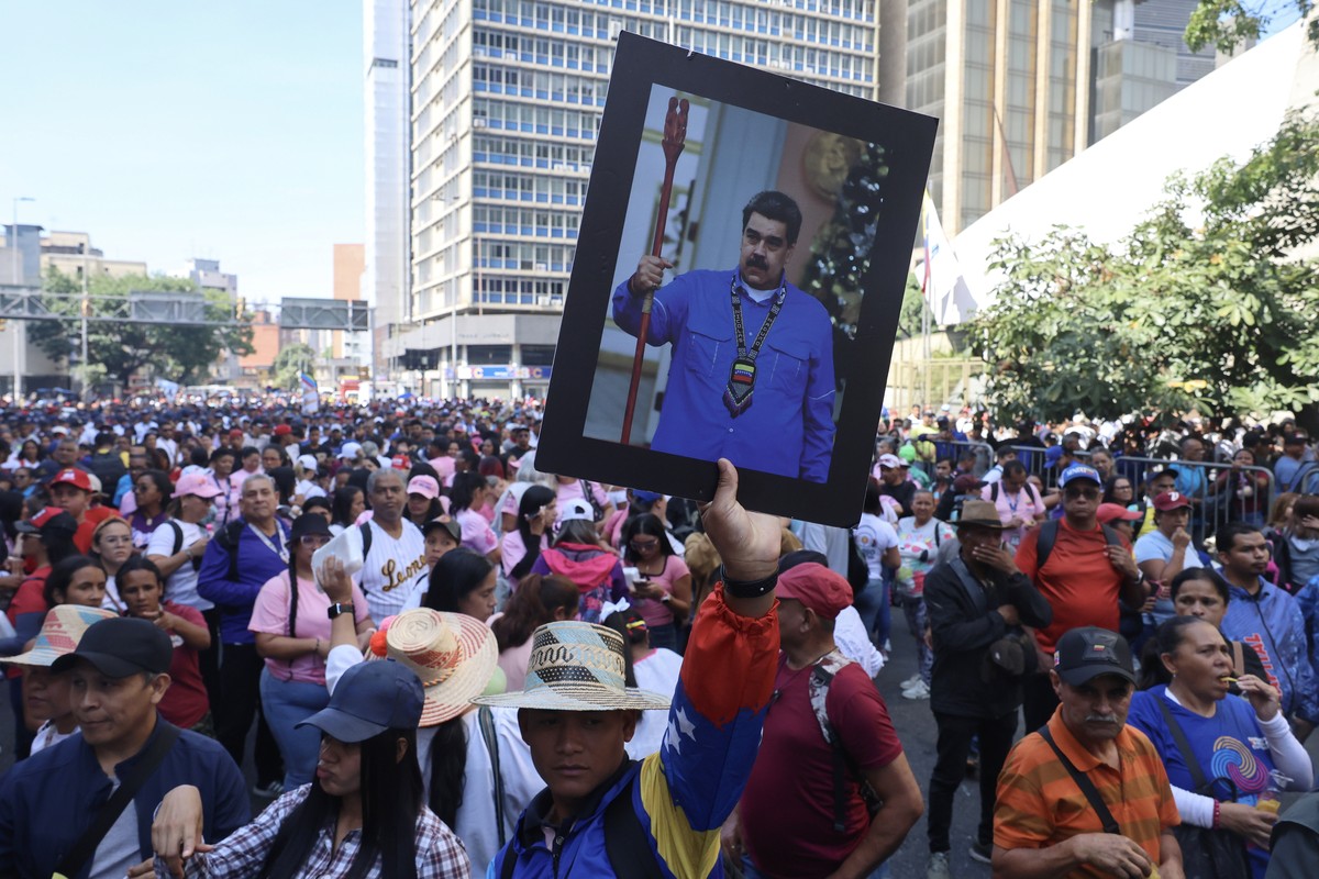 epaselect epa12878202 A person holds up a picture of ousted Venezuelan President Nicolas Maduro as people rally to mark the 20th anniversary of the Organic Law of Communal Councils in Caracas, Venezue ...