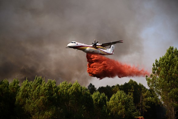A De Havilland Canada Dash 8-400 releases fire retardant as it flies over a forest near Blagon, during wildfires in southwestern France, Wednesday, July 29, 2026. (AP Photo/Emma Da Silva)
France Wildf ...