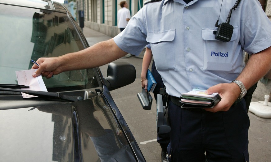 Ein Mitarbeiter des Polizeilichen Assistenzdienstes (PAD) verteilt am 4. August 2004 in Zuerich Strafzettel wegen Falschparkens. Der Polizeiliche Assistenzdienst ist eine Dienstabteilung der Zuercher  ...