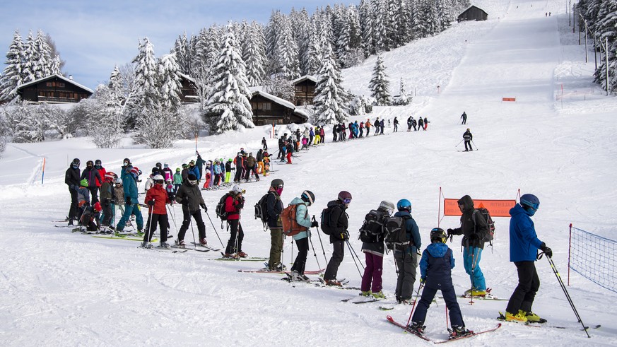 Des skieurs font la queue pour le teleski, en remontant sur la piste de ski afin de garder les distances, sur le domaine skiable des alpes vaudoises lors de la crise du Coronavirus (Covid-19) le samed ...