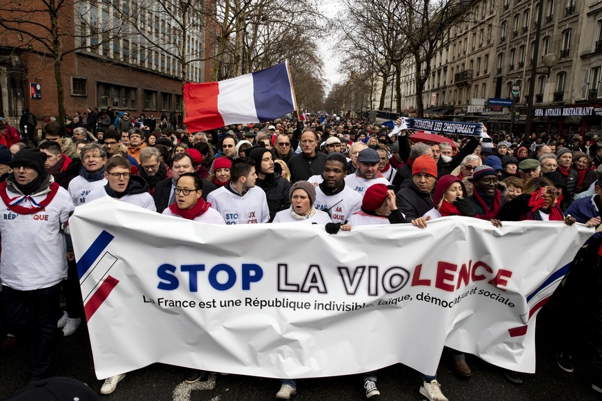 epa07325421 Protesters hold a banner reading &#039;Stop the Violence&#039; as thousands of &#039;Foulards Rouges&#039; (Red Scarfs) demonstrators march in support of the government policy in Paris, Fr ...