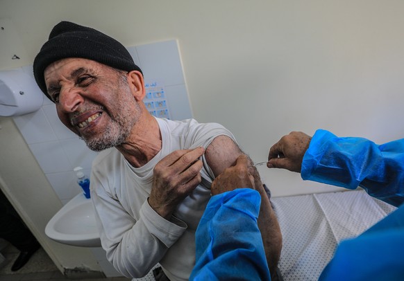 epa09080100 An elderly Palestinian man receives a dose of Russia&#039;s Sputnik V COVID-19 coronavirus vaccine at the Ministry of Health Sabha Al Harazeen clinic, in Al Shejaeiya neighborhood, in the  ...