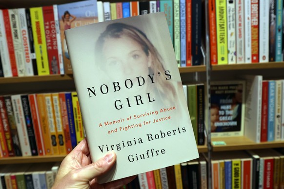 epa12469497 A person holds Virginia Giuffre's posthumous memoir, titled 'Nobody's Girl', at a bookshop after its publication in London, Britain, 21 October 2025. Giuffre, who took  ...