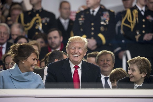 President Donald Trump shares a laugh with first lady Melania Trump and son Barron Trump as they sit in the reviewing stand during Trump's inaugural parade on Pennsylvania Ave. outside the White House in Washington, Friday, Jan. 20, 2017. (AP Photo/Andrew Harnik)