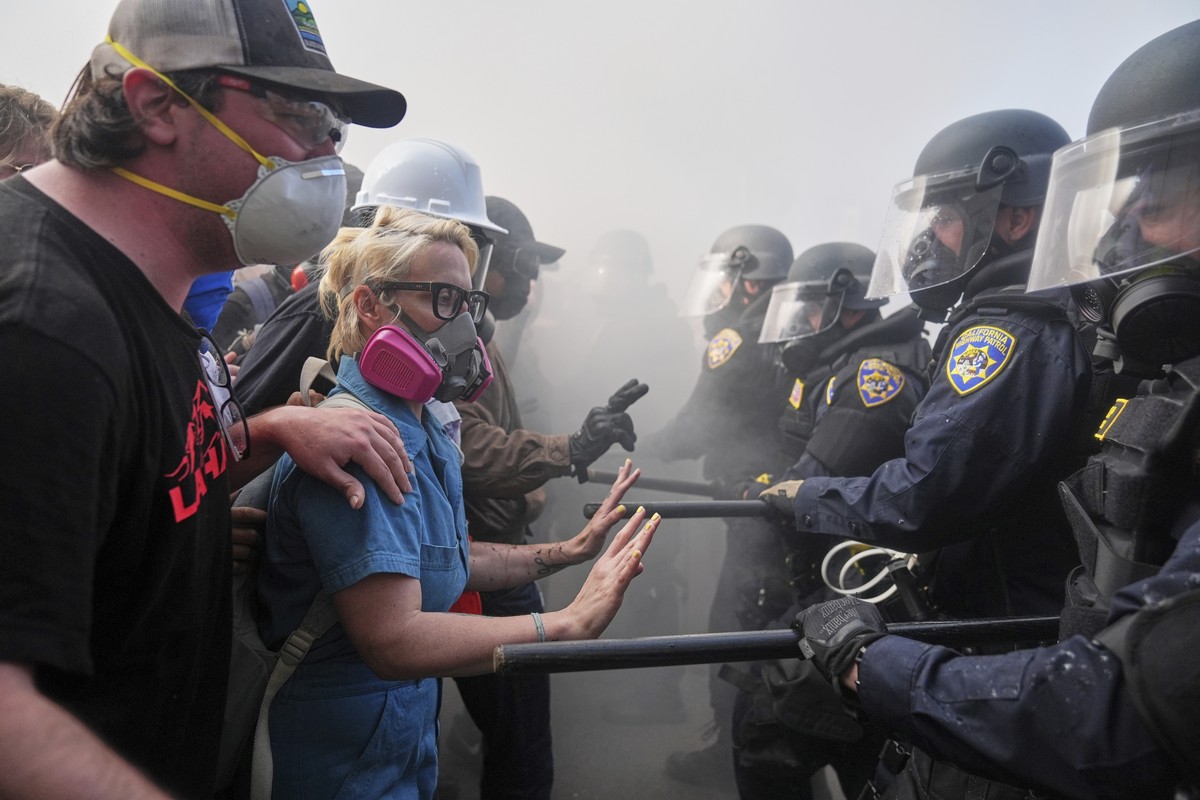 Protesters confront police on the 101 Freeway near the Metropolitan Detention Center of downtown Los Angeles, Sunday, June 8, 2025, following last night's immigration raid protest. (AP Photo/Jae  ...