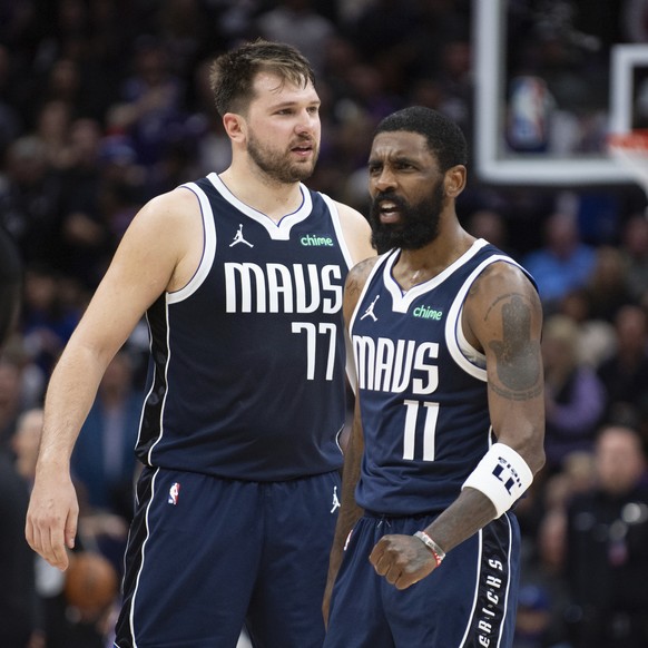 Dallas Mavericks guard Luka Doncic (77) and guard Kyrie Irving (11) react as the Sacramento Kings call for a timeout late in the second half of an NBA basketball game in Sacramento, Calif., Friday, Ma ...