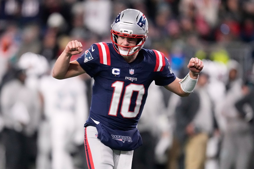 New England Patriots quarterback Drake Maye celebrates after a touchdown scored by running back TreVeyon Henderson during the second half of an NFL football game against the Miami Dolphins in Foxborou ...