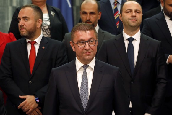 Hristijan Mickoski, center front, the new North Macedonia&#039;s prime minister and the members of his cabinet stand together for a photo after the parliament elected the new government, in the parlia ...