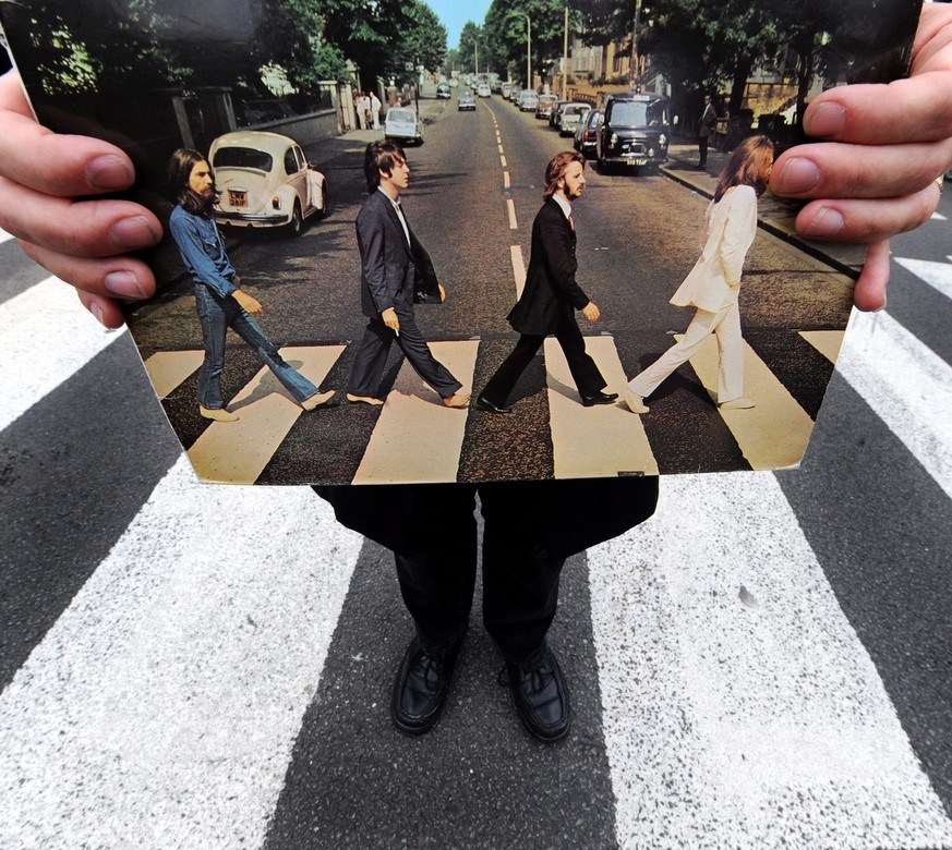 epa01818725 Richard Porter, a Beatles tour guide holds his copy of the Beatles Abbey Road album at Abbey Road in London, Britain, 08 August 2009. Hundreds of fans flocked to Abbey Road to walk across  ...