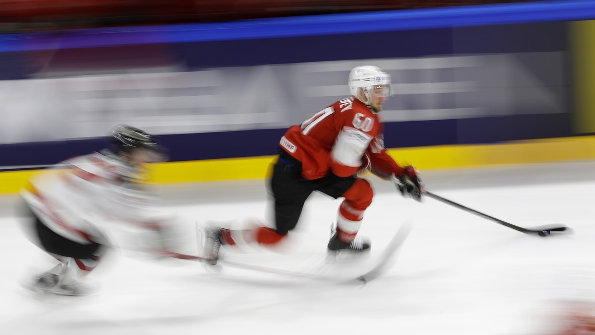 In this photo shot with a slow shutter speed Switzerland's Tristan Scherwey, right, chases the puck during the Ice Hockey World Championships semifinal match between Canada and Switzerland at the ...