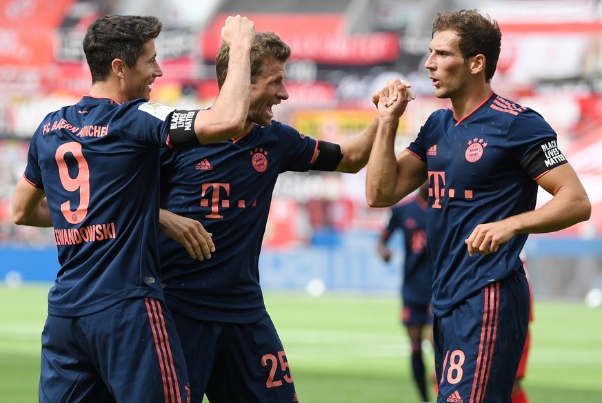 epa08469277 Robert Lewandowski of Muenchen (L) celebrates his team&#039;s fourth goal with teammates Thomas Mueller and Leon Goretzka (L-R) during the Bundesliga match between Bayer 04 Leverkusen and  ...