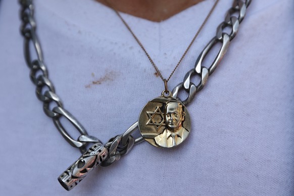 epa10271313 A person wears a pendant necklace depicting former Israeli Prime Minister and leader of the Likud party Benjamin Netanyahu, in Jerusalem, Israel, 28 October 2022. General elections are sch ...