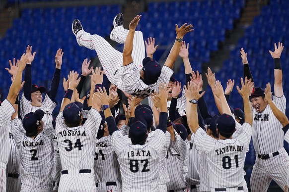 Team Japan celebrate with their manager Atsunori Inaba after the gold medal baseball game against the United States at the 2020 Summer Olympics, Saturday, Aug. 7, 2021, in Yokohama, Japan. Japan won 2 ...