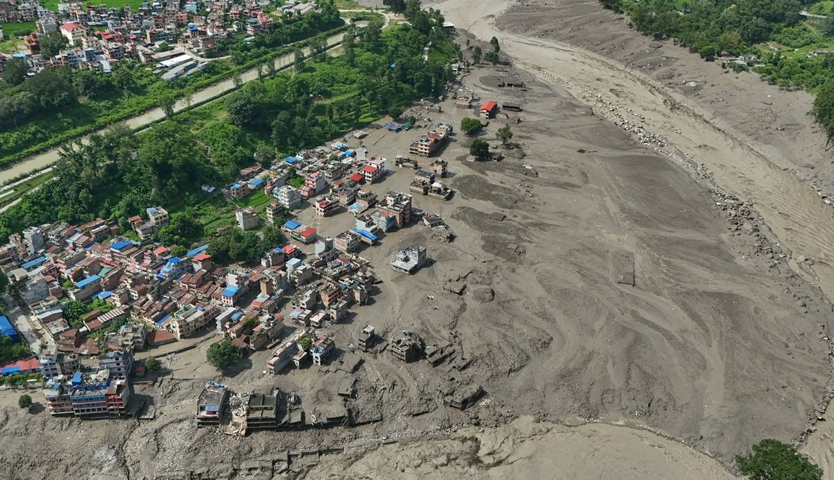 Damaged houses stand precariously near the swollen, debris-choked banks of the Trishuli River after flash floods in Nepal's Nuwakot district on Wednesday, Aug. 26, 2026. (AP Photo/Niranjan Shrest ...