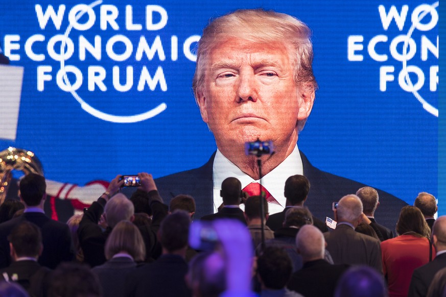 Participants watch the appearance of Donald Trump, President of the United States of America, on screen from an adjacent room, during the 48th Annual Meeting of the World Economic Forum, WEF, in Davos ...