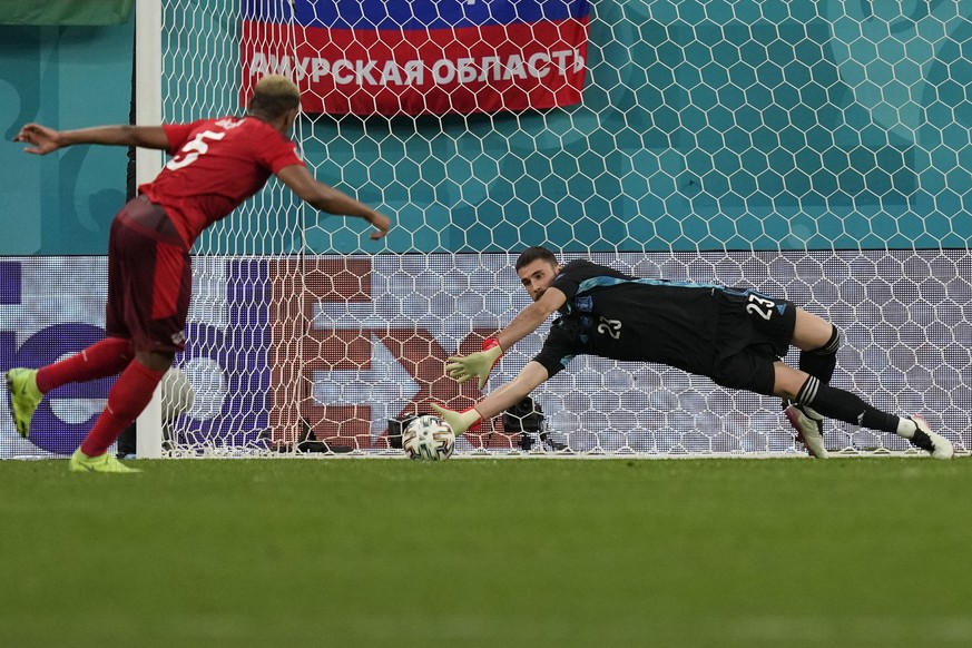 Spain&#039;s goalkeeper Unai Simon stops a penalty shot from Switzerland&#039;s Manuel Akanji, left, during a penalty shootout after extra time during the Euro 2020 soccer championship quarterfinal ma ...